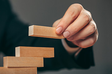 Image showing Man and wooden cubes on table. Management concept