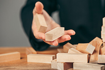 Image showing Man and wooden cubes on table. Management concept