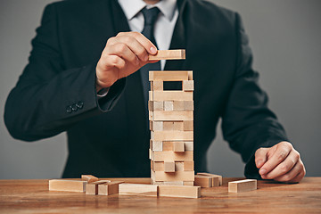 Image showing Man and wooden cubes on table. Management concept