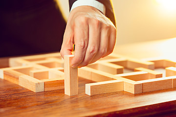 Image showing Man and wooden cubes on table. Management concept