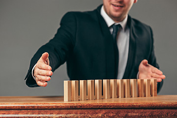 Image showing Man and wooden cubes on table. Management concept