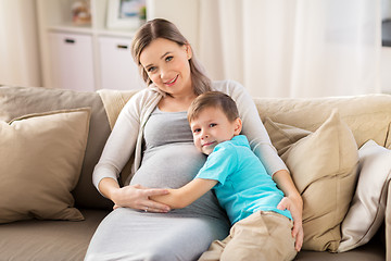 Image showing happy pregnant mother and son hugging at home