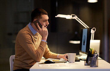 Image showing man with smartphone working late at night office