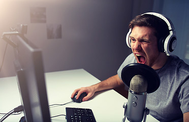 Image showing man in headset playing computer video game at home