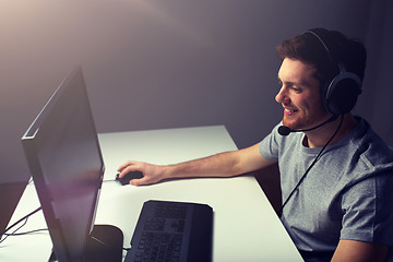 Image showing man in headset playing computer video game at home