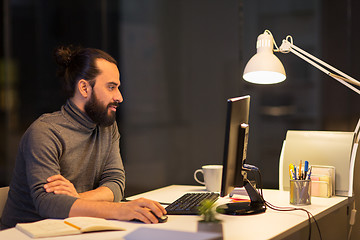 Image showing creative man with computer working at night office