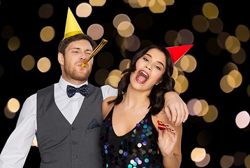 Image showing happy couple with party blowers having fun