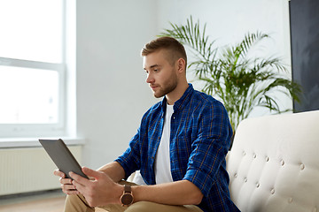 Image showing man with tablet pc sitting on sofa at office