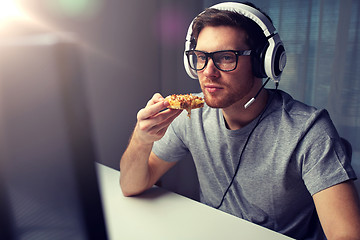 Image showing man in headset playing computer video game at home