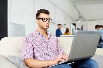 Image showing man in eyeglasses with laptop working at office