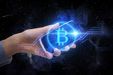 Image showing close up of hand with smartphone and bitcoin