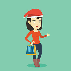 Image showing Woman in santa hat shopping for christmas gifts.