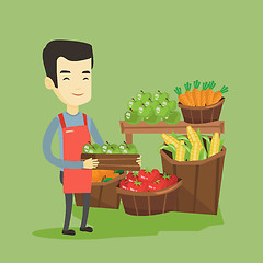 Image showing Supermarket worker with box full of apples.