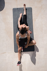 Image showing woman with personal trainer doing morning yoga exercises top vie