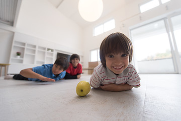 Image showing boys having fun with an apple on the floor