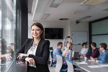 Image showing Elegant Woman Using Mobile Phone by window in office building