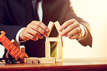 Image showing Man and wooden cubes on table. Management concept