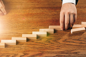 Image showing Man and wooden cubes on table. Management concept