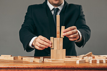 Image showing Man and wooden cubes on table. Management concept