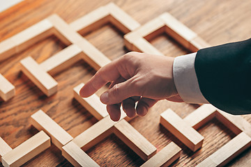 Image showing Man and wooden cubes on table. Management concept