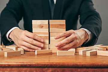 Image showing Man and wooden cubes on table. Management concept