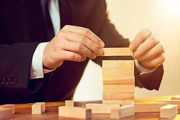 Image showing Man and wooden cubes on table. Management concept