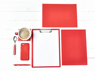 Image showing Office table desk with set of colorful supplies, white blank note pad, cup, pen on white background.