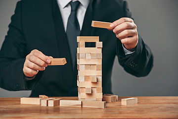 Image showing Man and wooden cubes on table. Management concept