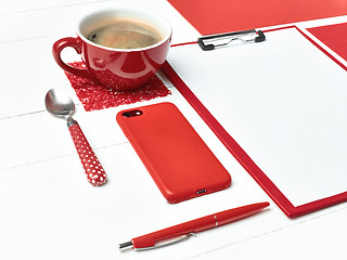 Image showing Office table desk with set of colorful supplies, white blank note pad, cup, pen on white background.