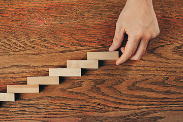 Image showing Man and wooden cubes on table. Management and marketing concepts