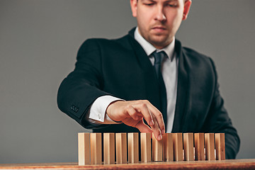 Image showing Man and wooden cubes on table. Management concept