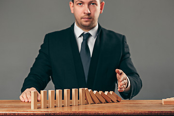 Image showing Man and wooden cubes on table. Management concept