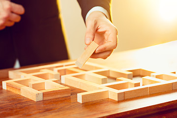 Image showing Man and wooden cubes on table. Management concept