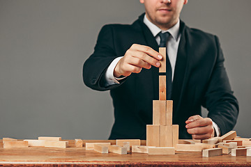 Image showing Man and wooden cubes on table. Management concept