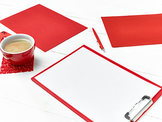 Image showing Office table desk with set of colorful supplies, white blank note pad, cup, pen on white background.