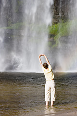 Image showing Woman doing gymnastics in front of a waterfall