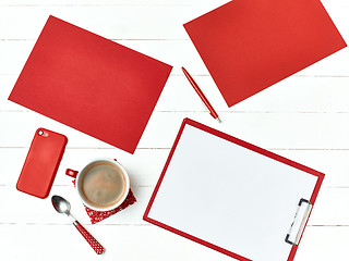 Image showing Office table desk with set of colorful supplies, white blank note pad, cup, pen on white background.