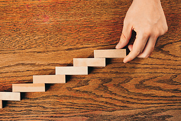 Image showing Man and wooden cubes on table. Management and marketing concepts