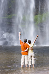 Image showing Couple in front of a tropical waterfall