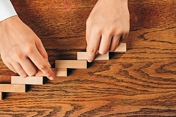 Image showing Man and wooden cubes on table. Management concept