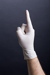 Image showing Male hand in latex glove (finger up)