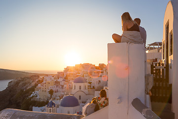 Image showing Couple watching sunrise and taking vacation photos at Santorini island, Greece.