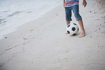 Image showing Young little boy playing on the beach with soccer ball. 