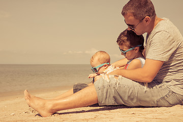 Image showing Father and children  playing on the beach at the day time.