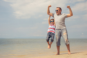 Image showing Father and son  playing on the beach at the day time.