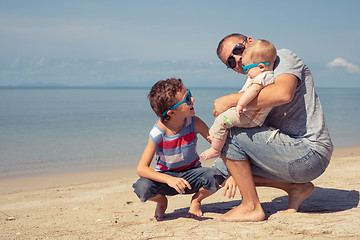 Image showing Father and children  playing on the beach at the day time.