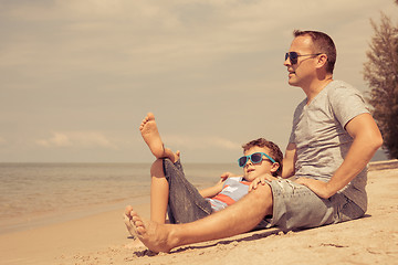 Image showing Father and son  playing on the beach at the day time.