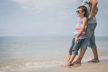 Image showing Father and son  playing on the beach at the day time.