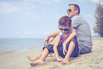 Image showing Portrait of young sad little boy and father sitting outdoors at 