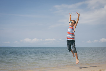 Image showing One happy little boy playing on the beach at the day time.